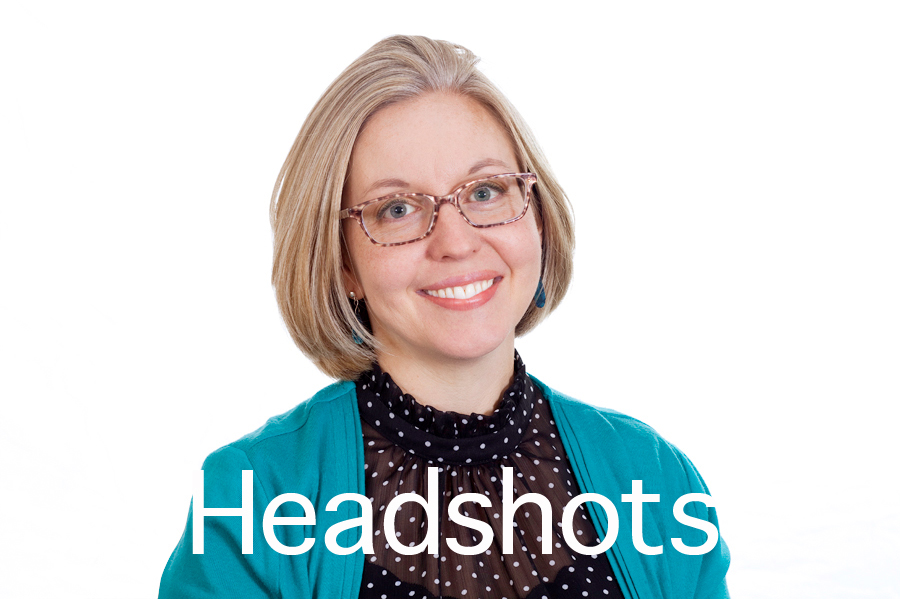 Headshots button. This Brian Charles Steel photo is a headshot of a white woman with blonde hair.  She is wearing glasses, a light blue green sweater and a black blouse with white polka dots.  She is centered in the frame, and the background is completely white.  The woman is lit with a Rembrandt style of lighting. 